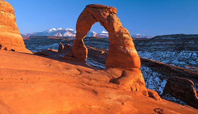 Delicate_Arch-La-Sal-Mtns_courtesy_680 The La Sal Mountains seen through Delicate Arch in Arches National Park.