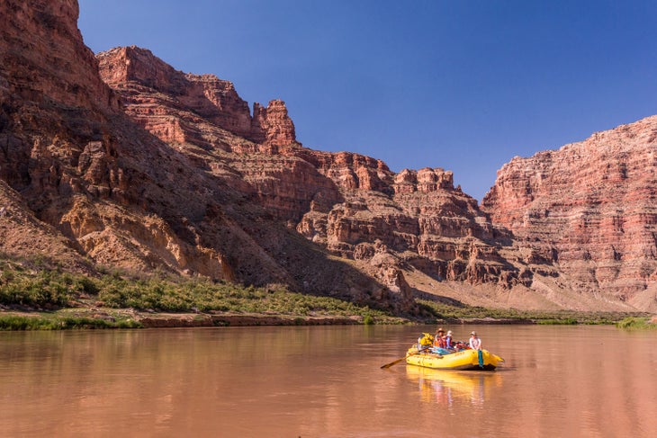 Rafting past the towering canyon walls of Cataract Canyon with OARS