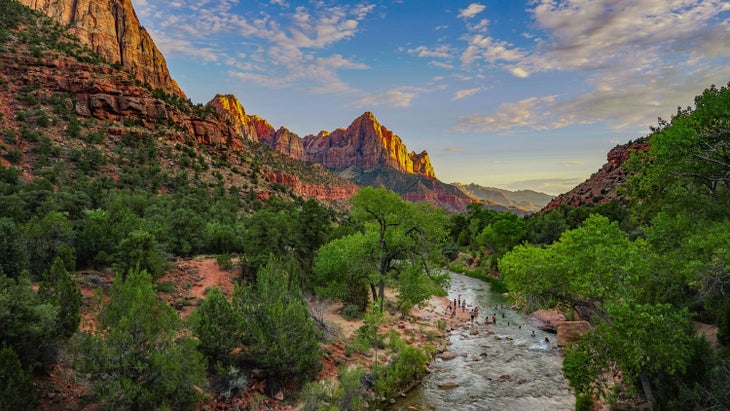 Swimmers in the Virgin River at the Grotto with the Watchman in the background in Zion National Park