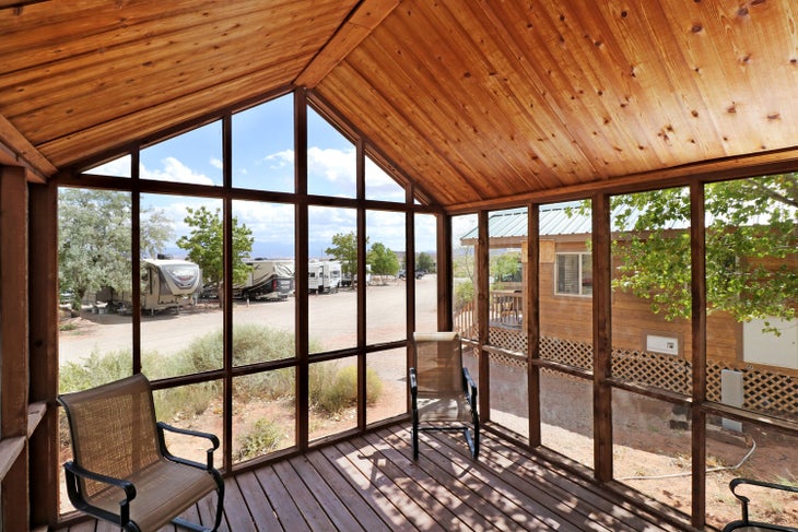 A cabin's shady porch at Archview RV Resort & Campground by Sun RV Resorts