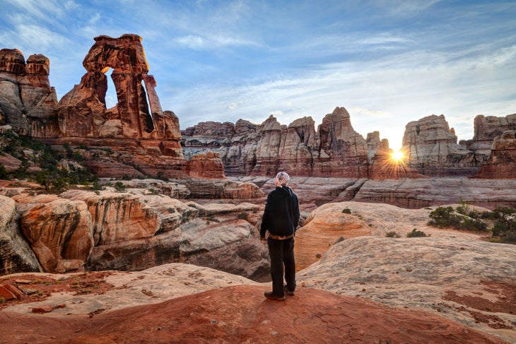 Needles hiker at Druid Arch in Canyonlands National Park